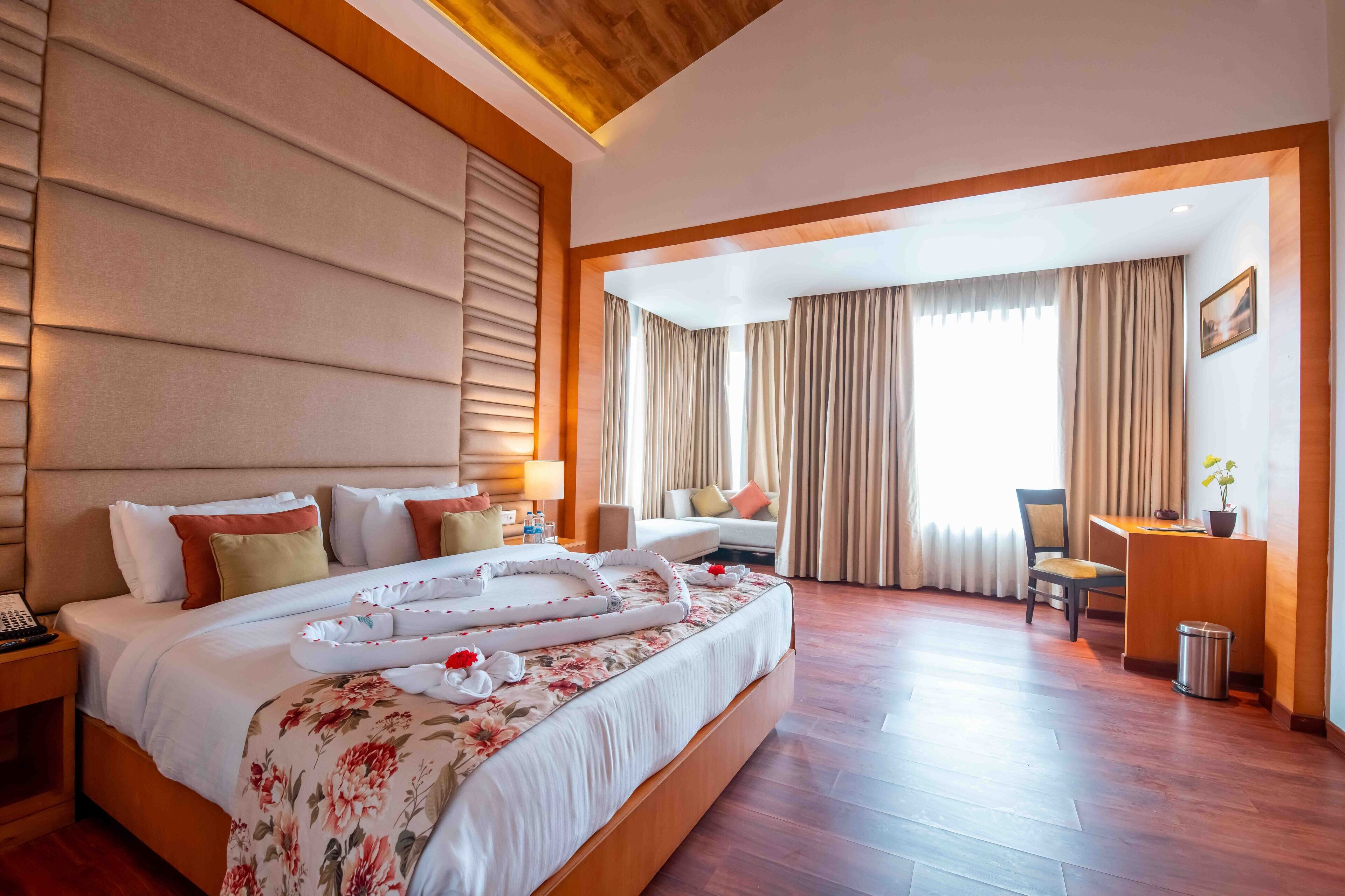 A hotel room with a large bed, a desk, and a chair.