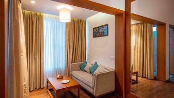 Una sala de estar acogedora con un sofá, una mesita y un espejo que refleja la habitación.