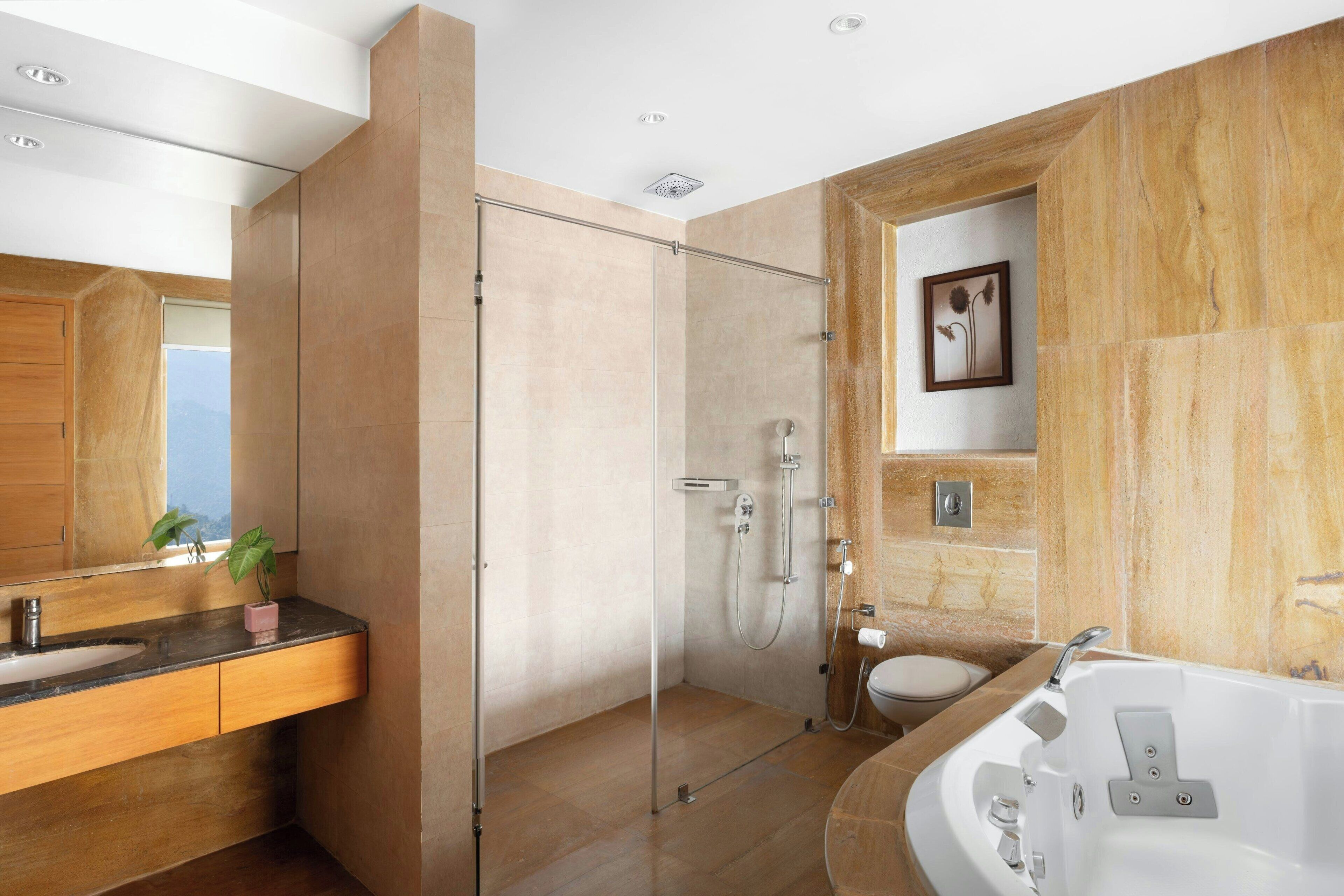 Ein modernes Badezimmer mit einer gläsernen Duschkabine, einer freistehenden Badewanne und einem Holzwaschtisch mit Waschbecken.
