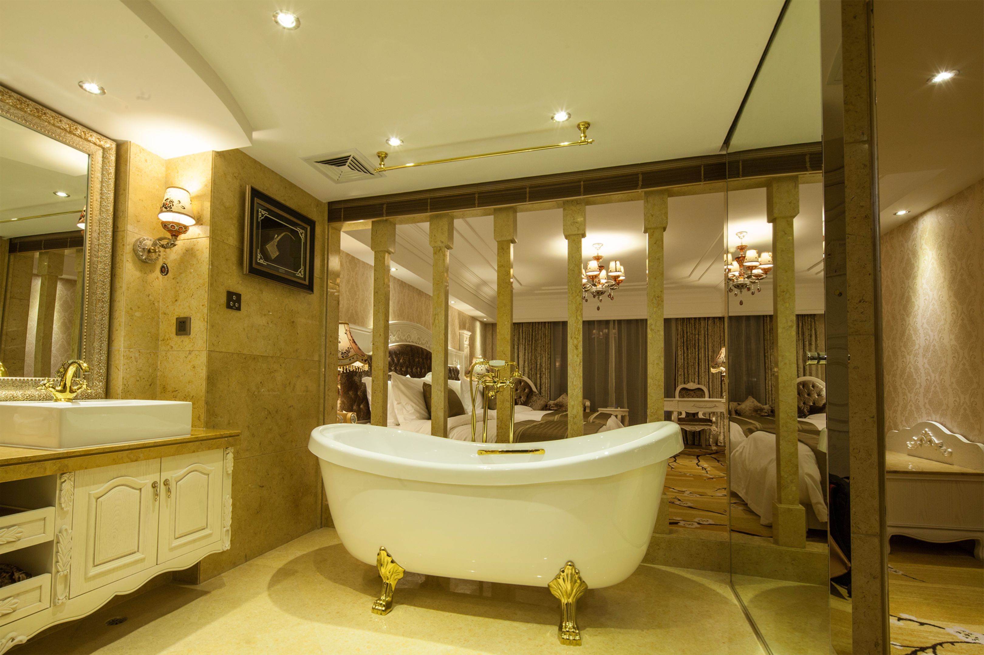 A luxurious bathroom with a freestanding bathtub, a large mirror, and a vanity with ornate cabinetry.