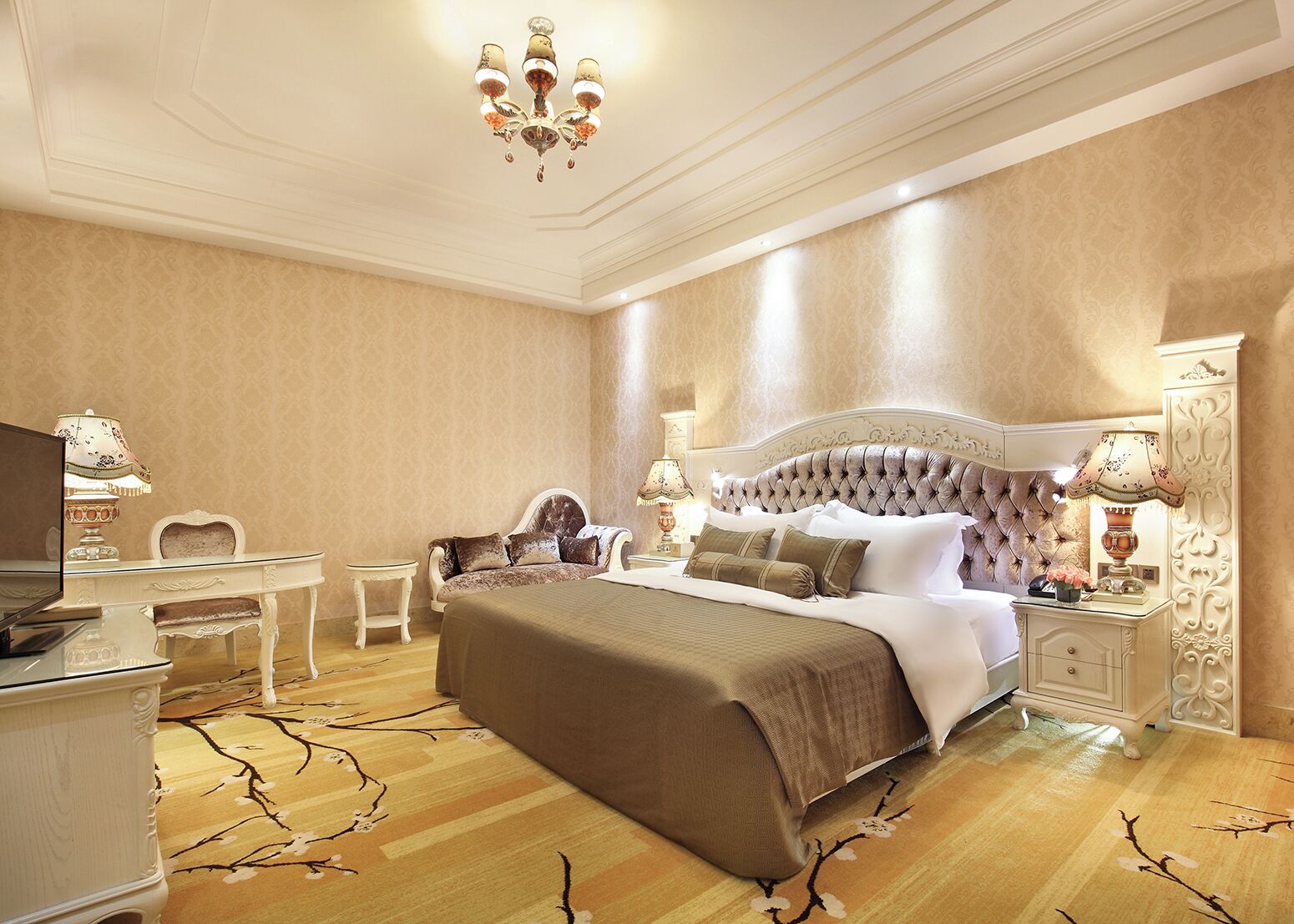 Um quarto luxuoso com uma cama grande, uma escrivaninha e duas luminárias.