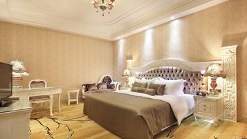 Um quarto luxuoso com uma cama grande, uma escrivaninha e duas luminárias.