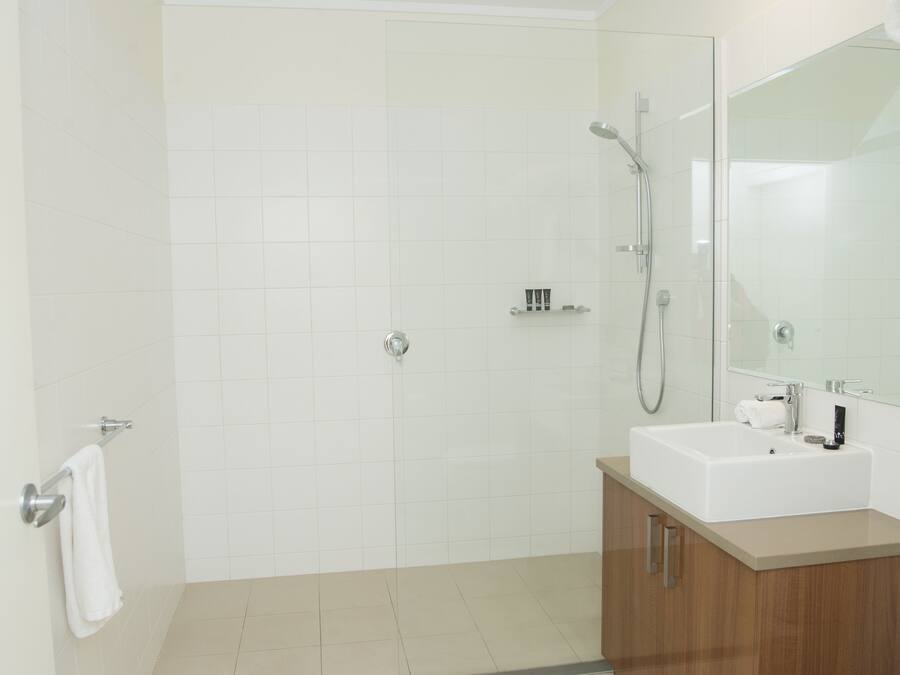 A modern bathroom with a shower, a sink, and a mirror.