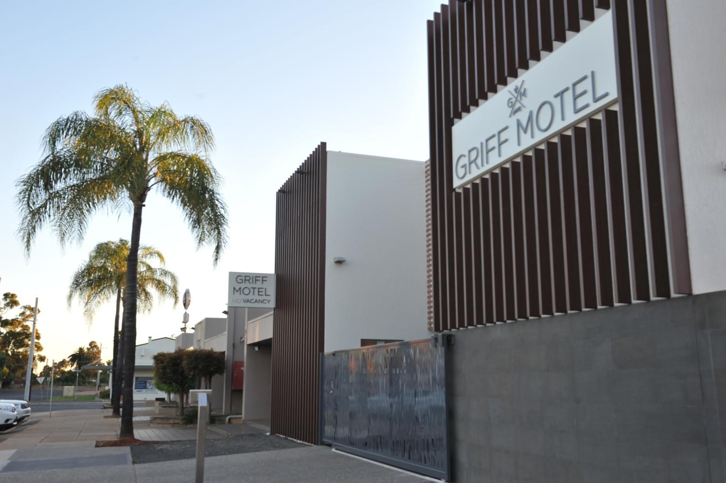 Un motel moderno con un cartel llamativo que dice "GRIFF MOTEL".