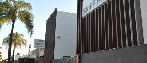The exterior of the Griff Motel with a modern design, featuring a prominent sign and a gated entrance.