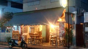 A restaurant with outdoor seating and a scooter parked outside. - Baanklangsoi (Prachuap Khiri Khan)