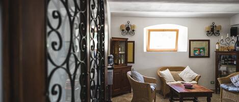 A cozy living room with wicker furniture, a wooden coffee table, and a cabinet.