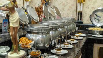 A buffet setup with multiple food containers and serving utensils.