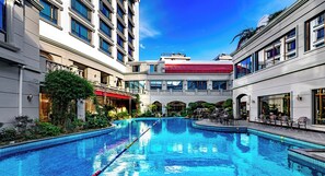 A large indoor swimming pool with multiple levels of balconies and seating areas. - Guilin Bravo Hotel Grand Wing (Guilin)