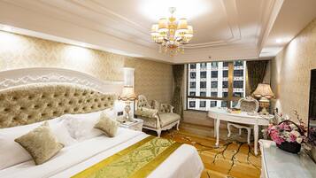 Um quarto luxuoso com uma cama grande, um candelabro, uma escrivaninha e vista para a cidade.
