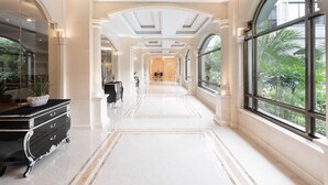 En storslagen hall med ett marmorgolv, stora fönster och klassisk arkitektur.