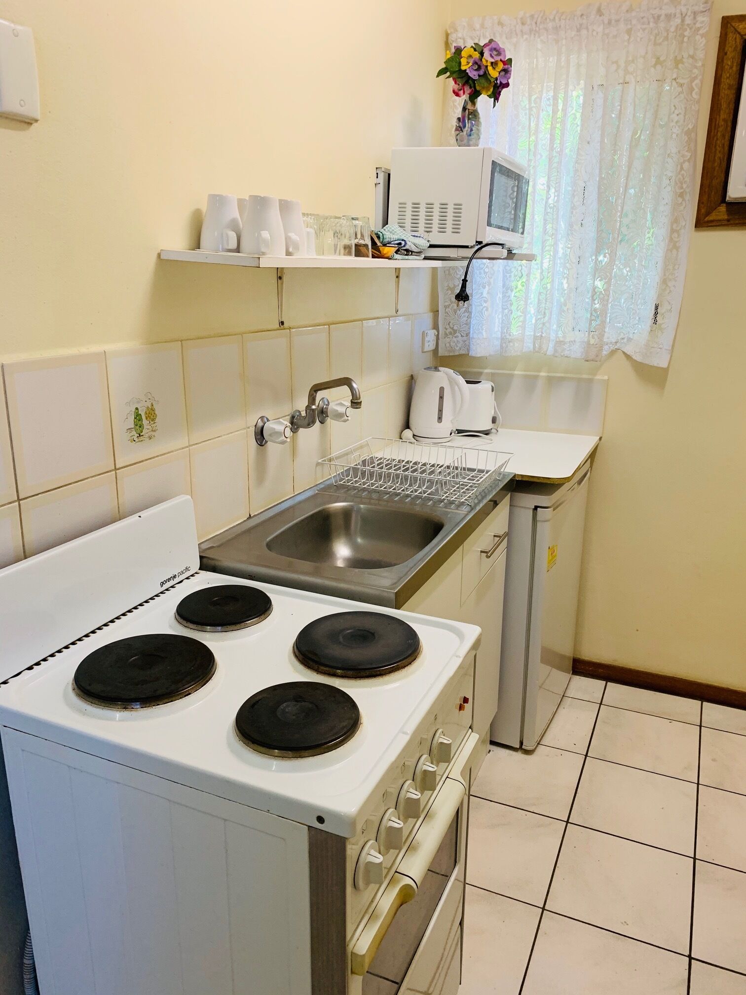 Una cocina con estufa, lavaplatos y microondas.