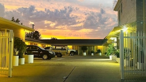 A motel with a parking lot, a gated entrance, and a building with an 'Office' sign. - Angel's Rest Motel (Moree)