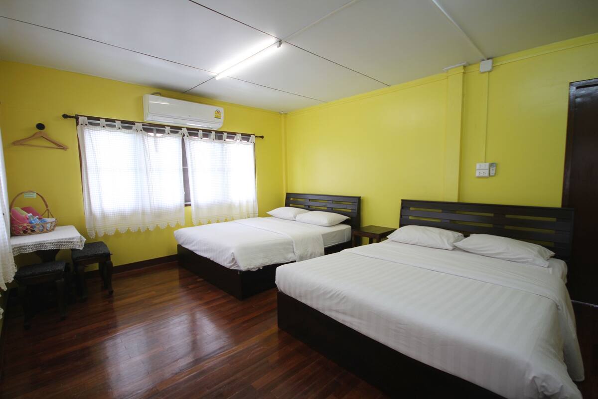 A room with two beds, a table, and a chair.