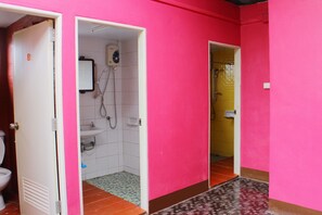 A bathroom with a pink wall, a white sink, and a shower. - Baan Bua Homestay - Hostel (Chiang Rai)