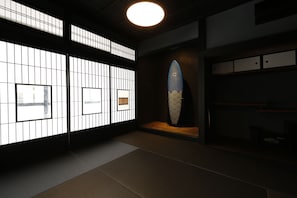 A traditional Japanese room with tatami flooring, shoji screens, and a surfboard display. - ZEN VAGUE - Hostel (Kamakura)