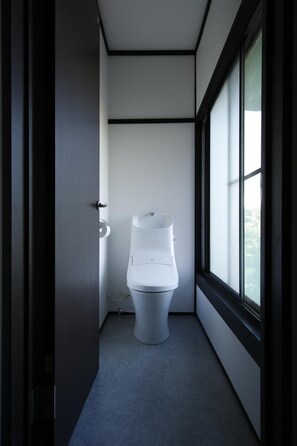 A narrow hallway with a toilet and a window on one side. - ZEN VAGUE - Hostel (Kamakura)
