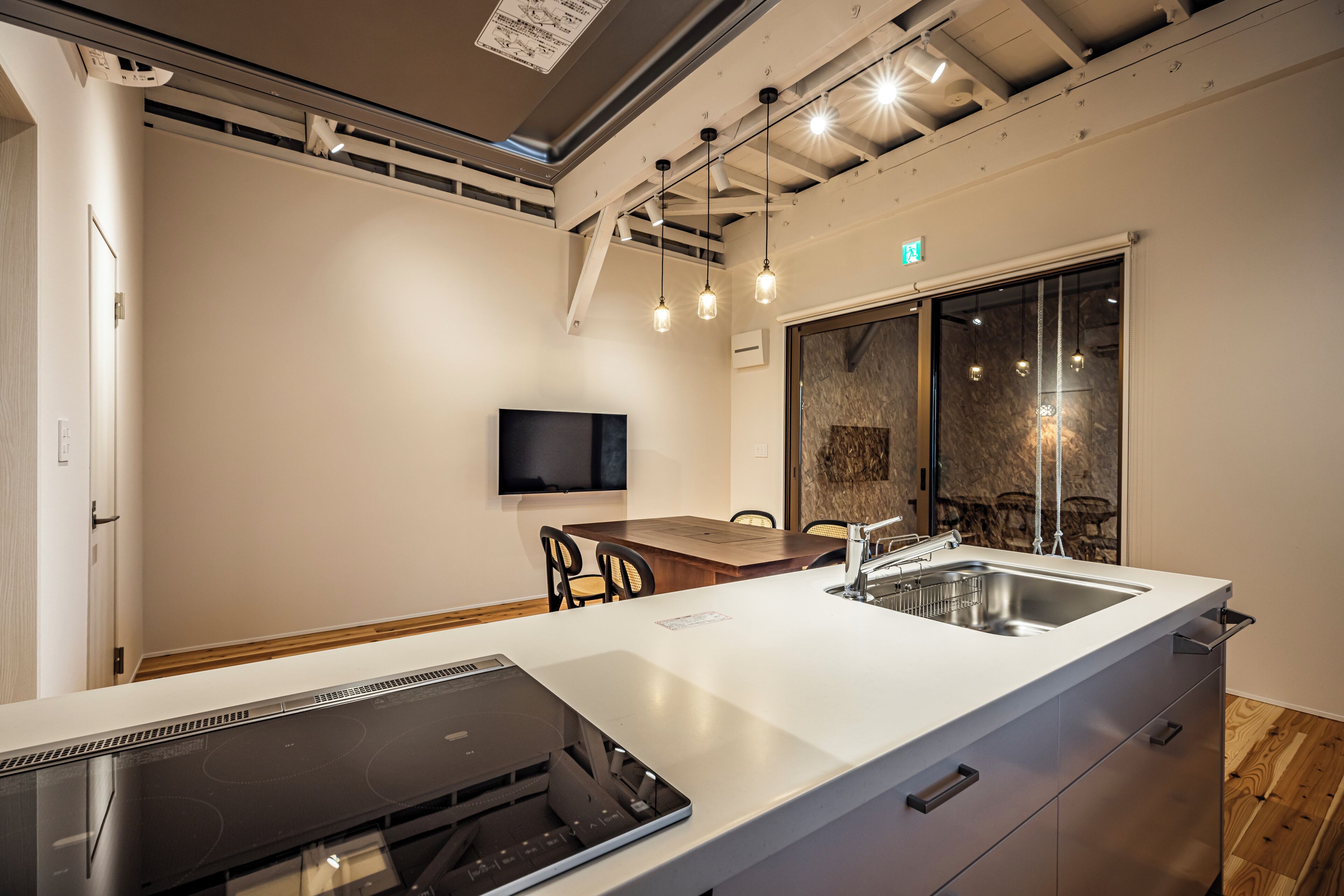 A modern kitchen with a central island, built-in appliances, and pendant lighting.