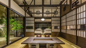 A traditional Japanese-style room with tatami flooring, a low table with cushions, and sliding doors. - Nihon Iro (Shizuoka)
