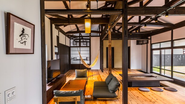 A modern interior with wooden floors, a hammock, and a large window offering a view. - Nihon Iro (Shizuoka)