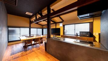 Una cocina moderna con una mesa y sillas de madera, horno empotrado y un amplio ventanal que proporciona luz natural.