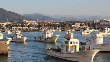 A marina with multiple boats docked, surrounded by buildings and mountains in the background.