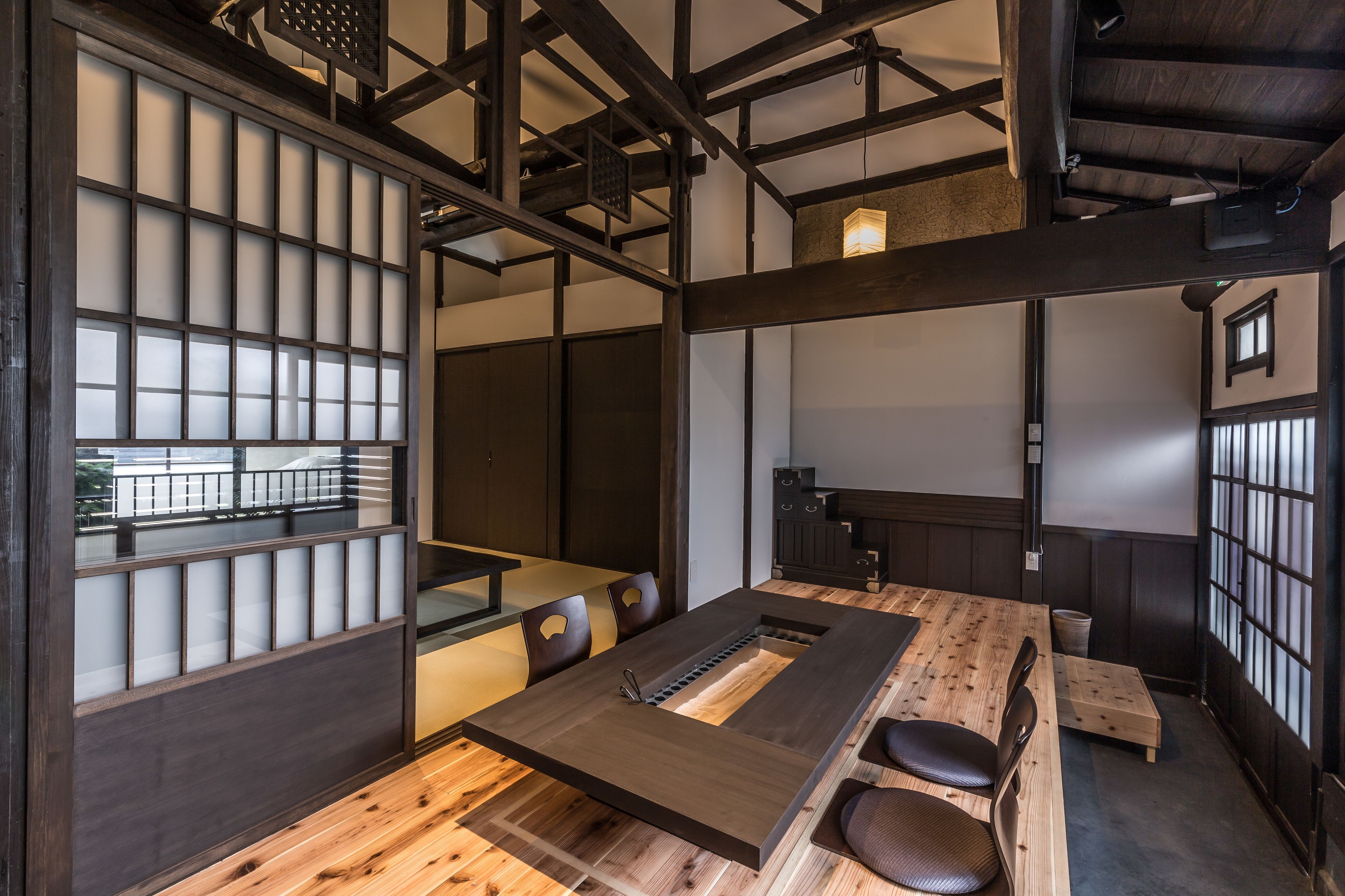 A traditional Japanese-style room with tatami flooring, a low table, and shoji screens.