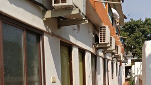 A narrow corridor with buildings on either side, featuring air conditioning units, doors, and windows. - Villa Mer (Baga)
