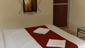 A hotel room with a bed, a mirror, a wardrobe, and a ceiling fan. - Villa Mer (Baga)