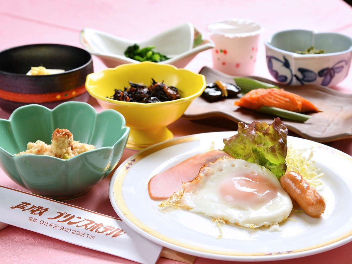 A table with a plate of food including an egg, ham, and vegetables, accompanied by small bowls of side dishes.