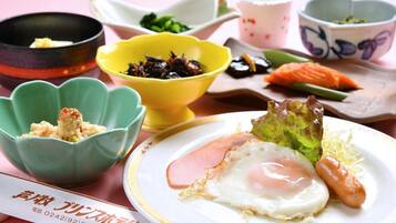 A table with a plate of food including an egg, ham, and vegetables, accompanied by small bowls of side dishes.