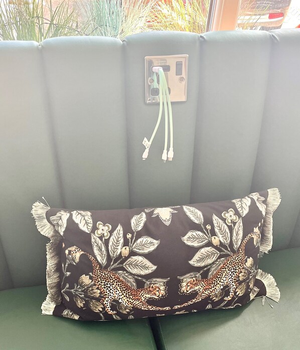 A grey sofa with a cushion featuring a cheetah and leaf pattern. - Clifton Court Metro Hotel (Blackpool)