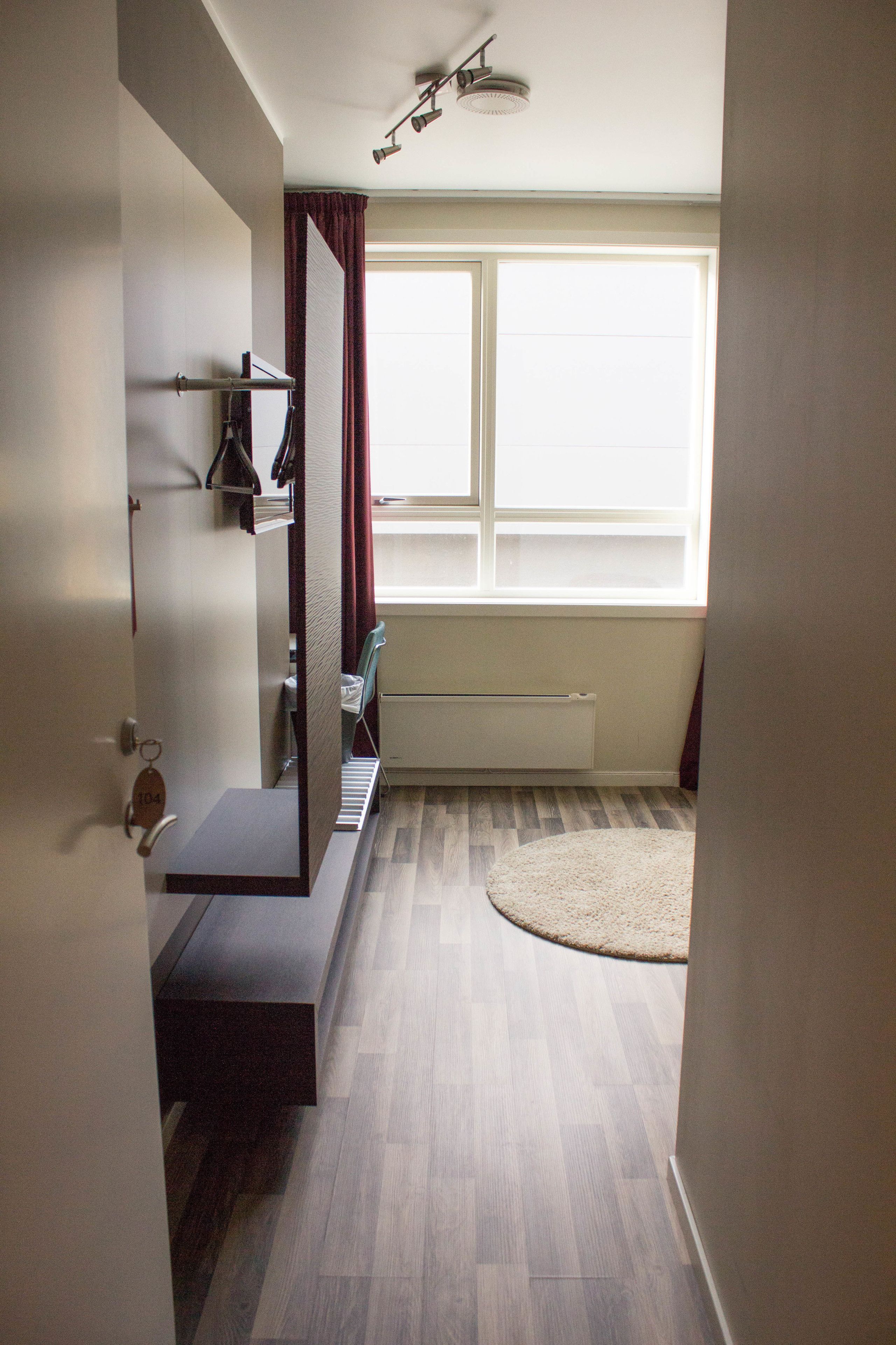 A modern bathroom with a shower, a toilet, a sink, and a window providing natural light.