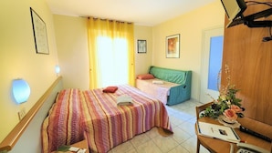 A hotel room with a bed, a desk with a telephone, and a window with curtains. - Hotel Lucerna (Taggia)