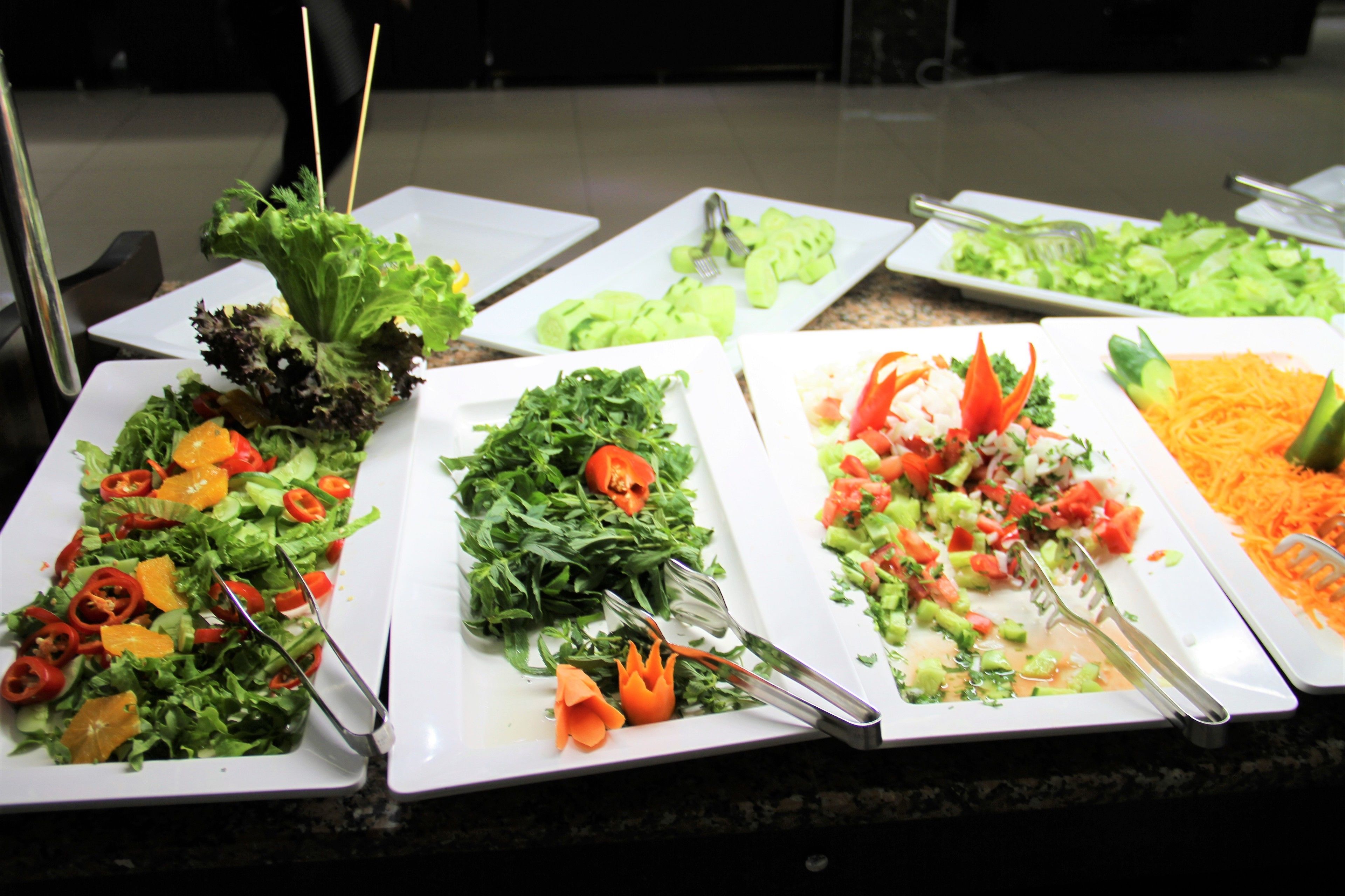 A buffet with various salads and vegetables.