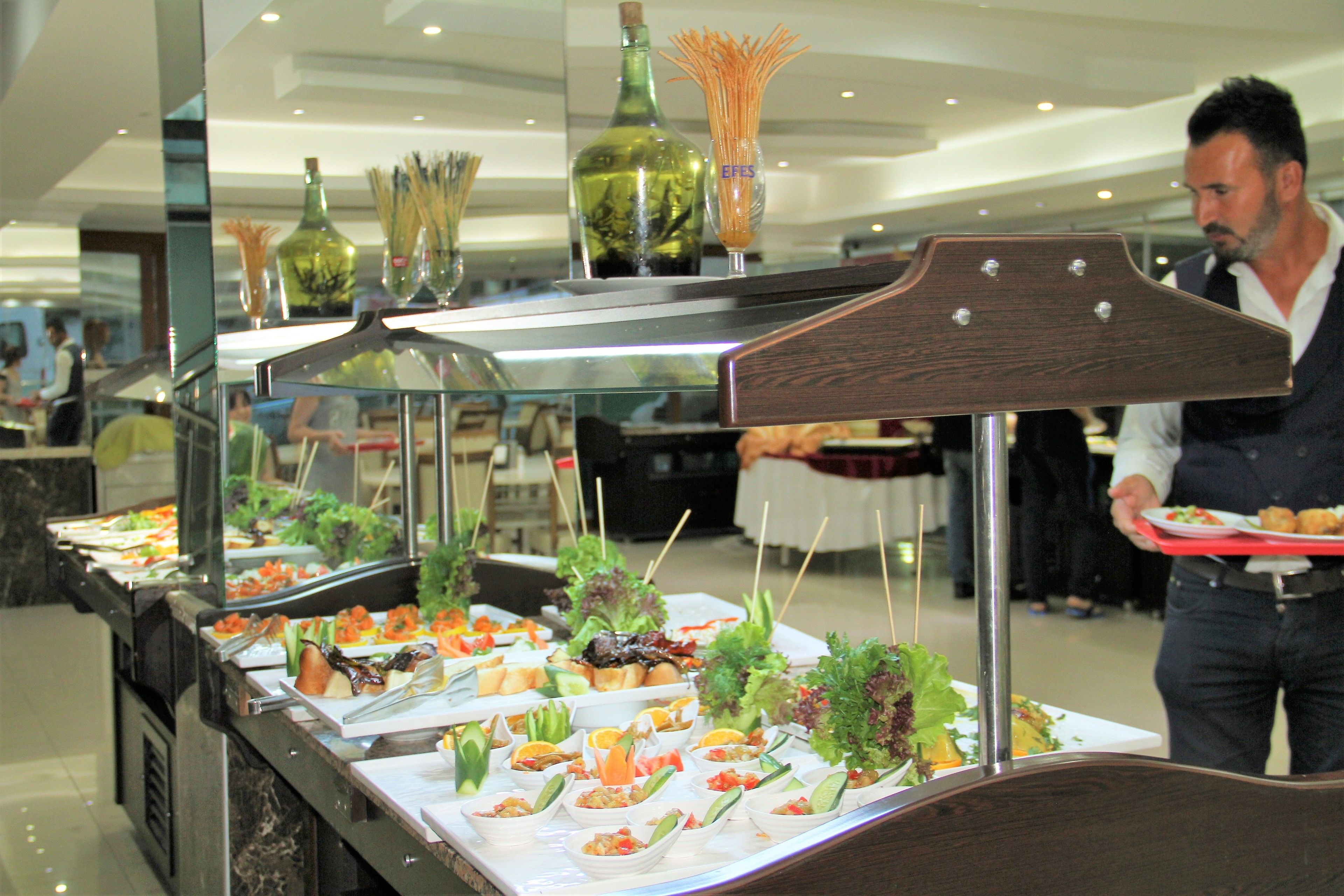A buffet setup with various food items and decorative bottles.