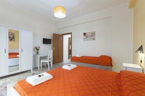 A hotel room with a large bed, a desk, a chair, and a television on the wall. - B&B La Primula (Pompei)