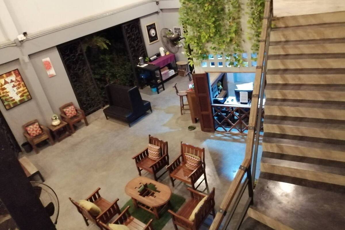 A lobby with a staircase, seating area, and a reception desk.