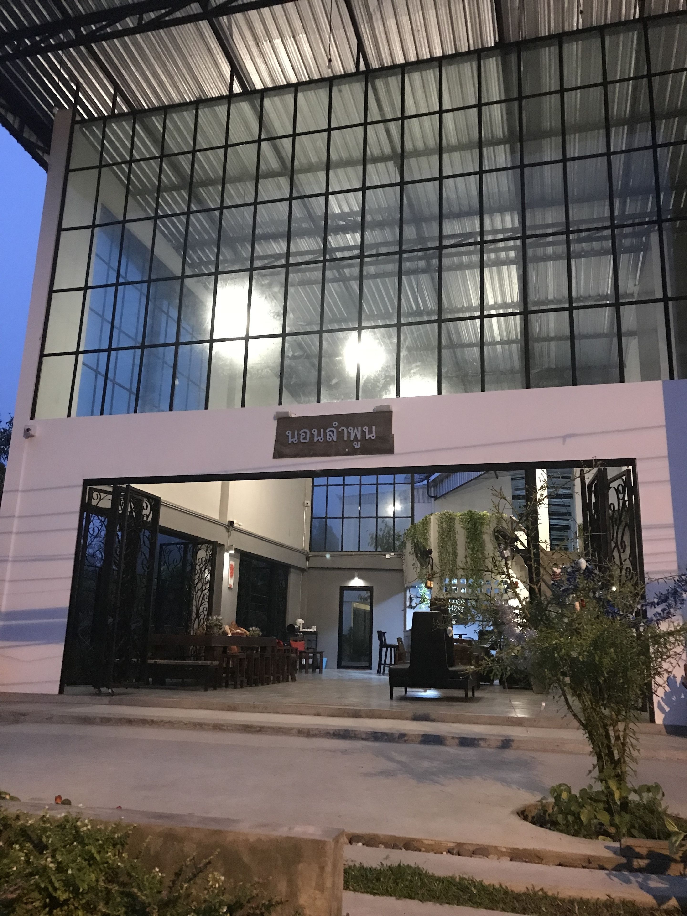 A modern building with large glass windows and a sign above the entrance.
