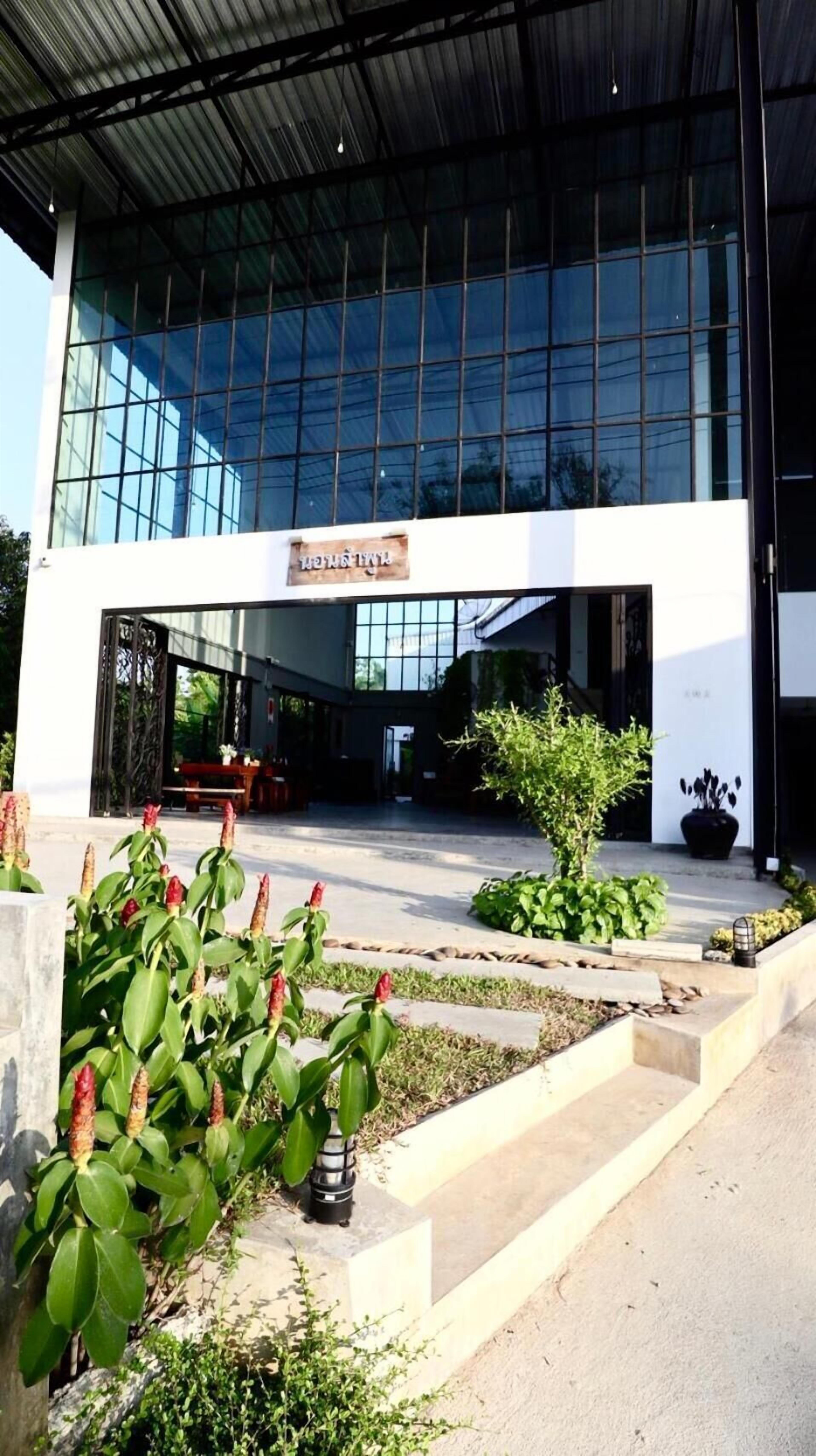 A modern building with a glass facade and a sign above the entrance.