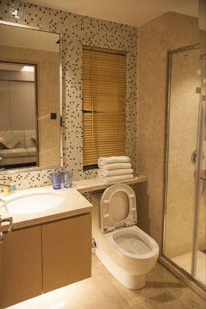 A bathroom with a toilet, sink, and shower.