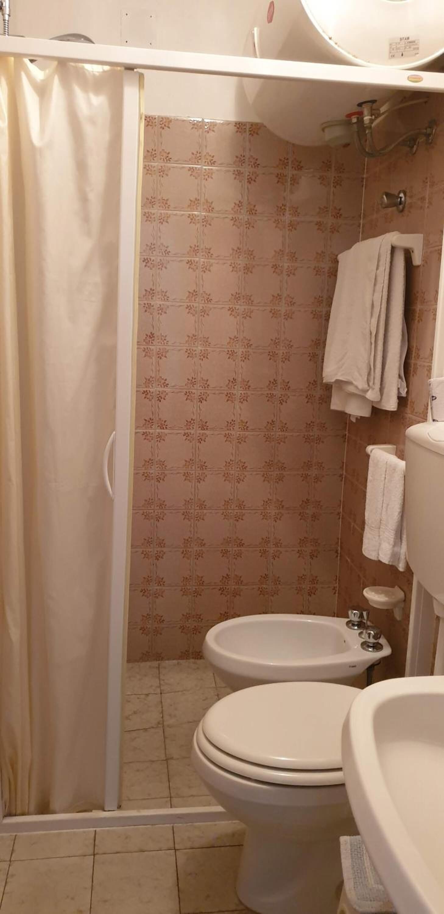 Ein Badezimmer mit Dusche, Toilette und Waschbecken.