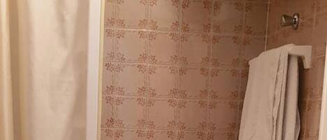 Ein Badezimmer mit Dusche, Toilette und Waschbecken.