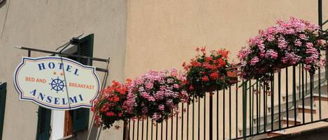Een hotelschild met 'HOTEL ANSELMI' en faciliteiten vermeld als 'Bed & Breakfast'.