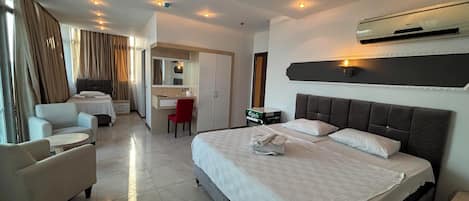 Una habitación de hotel con una cama grande, un escritorio, una silla y un sofá.