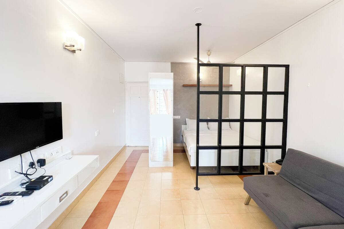 Un salon moderne avec un téléviseur à écran plat, un canapé, une table basse et un mur de séparation.