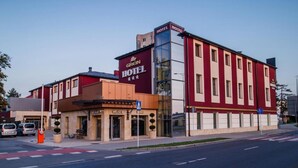 A hotel with a modern facade, a ground floor restaurant, and a clear blue sky.