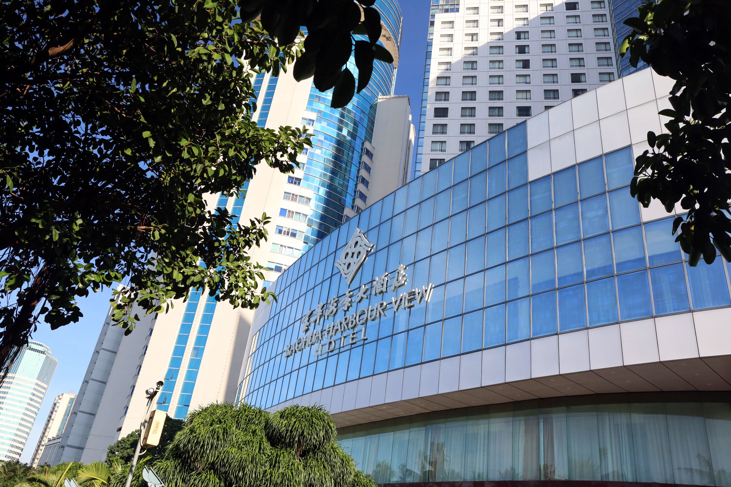 Un hotel moderno con fachada de vidrio y señalización en un idioma extranjero.