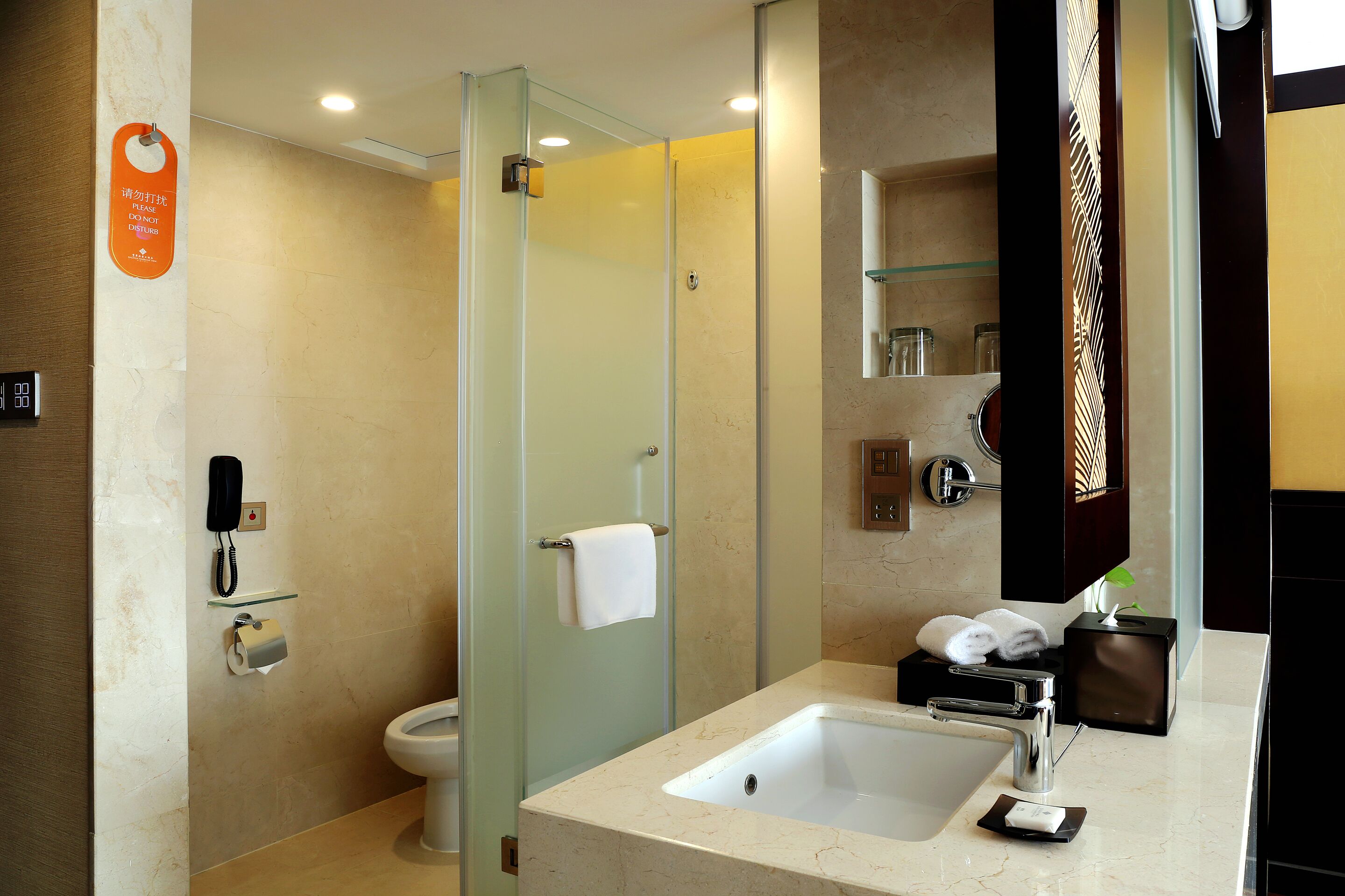 Une salle de bain moderne avec une douche à parois de verre, un lavabo avec un miroir et des toilettes.