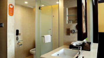 A modern bathroom with a glass shower enclosure, a sink with a mirror, and a toilet.